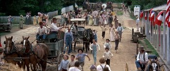 Movie still from “Tom Sawyer” (1973), directed by Don Taylor – A group of people walking down a dirt road; Wide shot, High angle