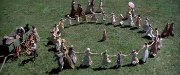 Movie still from “Tom Sawyer” (1973), directed by Don Taylor – A group of people holding hands in a circle; Extreme Wide shot, Overhead angle