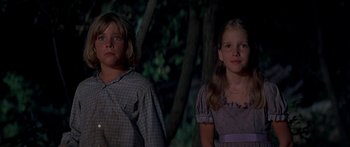 Movie still from “Tom Sawyer” (1973), directed by Don Taylor – Two young children standing next to each other in the dark; Medium shot, Low angle