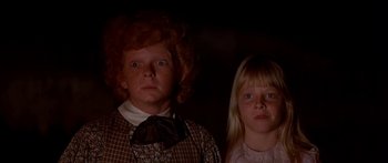 Movie still from “Tom Sawyer” (1973), directed by Don Taylor – A woman and a girl standing next to each other in a dark room; Close Up shot, Low angle