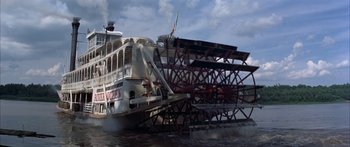 Movie still from “Tom Sawyer” (1973), directed by Don Taylor – A large white boat floating on top of a body of water; Extreme Wide shot, Low angle