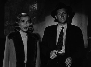 Movie still from “Too Late for Tears” (1949), directed by Byron Haskin – A man and a woman standing next to each other; Medium shot, Low angle