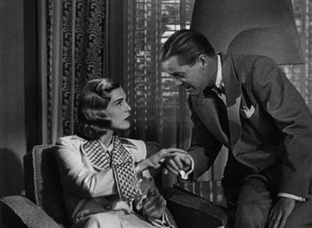 Movie still from “Too Late for Tears” (1949), directed by Byron Haskin – An old photo of a man and a woman; Medium shot, Over the shoulder angle