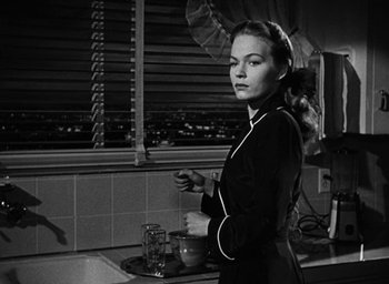 Movie still from “Too Late for Tears” (1949), directed by Byron Haskin – A black and white photo of a woman in a kitchen; Medium shot, Low angle