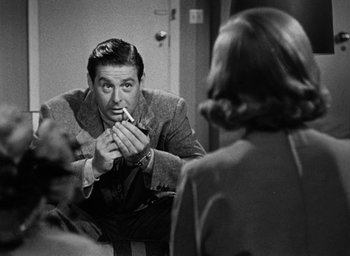 Movie still from “Too Late for Tears” (1949), directed by Byron Haskin – A black - and - white photo of a man smoking a cigarette; Medium shot, Over the shoulder angle