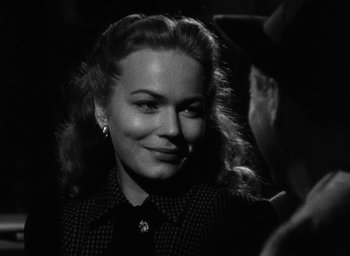 Movie still from “Too Late for Tears” (1949), directed by Byron Haskin – A black - and - white photo of a woman smiling; Close Up shot, Over the shoulder angle