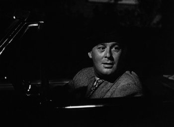 Movie still from “Too Late for Tears” (1949), directed by Byron Haskin – A black and white photo of a man in a car; Close Up shot, Over the shoulder angle