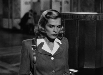 Movie still from “Too Late for Tears” (1949), directed by Byron Haskin – An old photo of a woman with a purse; Medium shot, Low angle