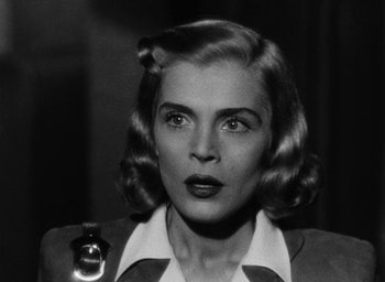 Movie still from “Too Late for Tears” (1949), directed by Byron Haskin – An old photo of a woman with a bottle in her hand; Close Up shot, Low angle