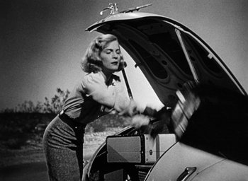 Movie still from “Too Late for Tears” (1949), directed by Byron Haskin – A woman standing in front of an open car trunk; Medium shot, Low angle