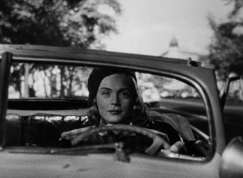 Movie still from “Too Late for Tears” (1949), directed by Byron Haskin – A black and white photo of a woman in the back of a car; Close Up shot, Low angle