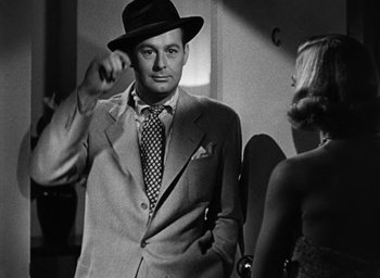 Movie still from “Too Late for Tears” (1949), directed by Byron Haskin – A black and white photo of a man in a suit and tie; Close Up shot, Over the shoulder angle