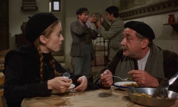 Movie still from “Tristana” (1970), directed by Luis Buñuel – A man and a woman sitting at a dinner table; Medium shot, Over the shoulder angle