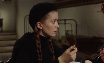 Movie still from “Tristana” (1970), directed by Luis Buñuel – A young woman in a black hat is looking at her cell phone; Close Up shot, Over the shoulder angle