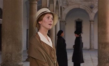 Movie still from “Tristana” (1970), directed by Luis Buñuel – A woman wearing a hat standing in front of two other women; Medium shot, Low angle