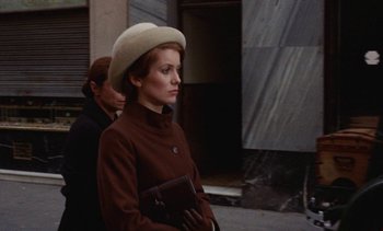 Movie still from “Tristana” (1970), directed by Luis Buñuel – A woman in a brown coat and a white hat; Medium shot, Low angle