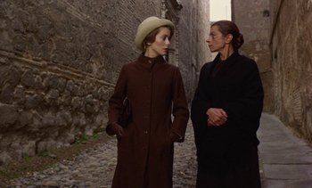 Movie still from “Tristana” (1970), directed by Luis Buñuel – Two women standing next to each other on a street; Medium shot, Over the shoulder angle