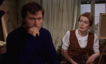 Movie still from “Tristana” (1970), directed by Luis Buñuel – A man and a woman sitting next to each other in a room; Medium shot, Over the shoulder angle