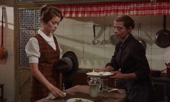 Movie still from “Tristana” (1970), directed by Luis Buñuel – Two women in a kitchen preparing a meal together; Medium shot, High angle