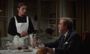 Movie still from “Tristana” (1970), directed by Luis Buñuel – An older man sitting at a dinner table with a woman; Medium shot, Over the shoulder angle