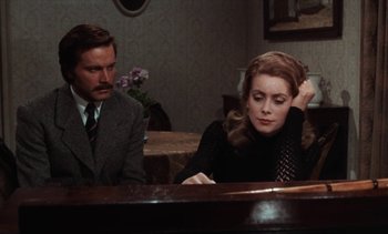 Movie still from “Tristana” (1970), directed by Luis Buñuel – A man and a woman sitting in front of a table; Medium shot, High angle