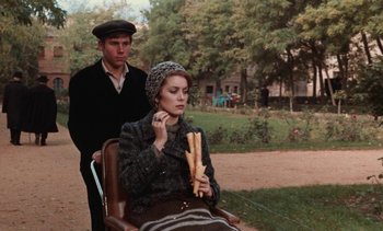Movie still from “Tristana” (1970), directed by Luis Buñuel – A man and a woman sitting in a chair outside; Medium shot, Over the shoulder angle