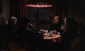 Movie still from “Tristana” (1970), directed by Luis Buñuel – A group of people sitting at a table with drinks; Wide shot, High angle