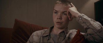 Movie still from “Wild Bill” (2011), directed by Dexter Fletcher – A young man sitting in a chair with his hand up to his head; Close Up shot, High angle