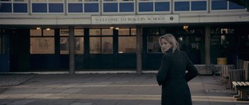 Movie still from “Wild Bill” (2011), directed by Dexter Fletcher – A woman standing in front of a school building; Wide shot, Low angle