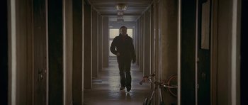 Movie still from “Wild Bill” (2011), directed by Dexter Fletcher – A man walking down a hallway with a bike in the background; Wide shot, Low angle