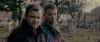 Movie still from “Wild Bill” (2011), directed by Dexter Fletcher – A couple of men standing next to each other in a cemetery; Close Up shot, Low angle