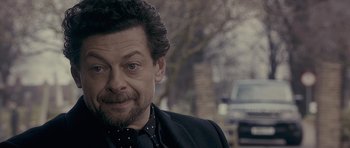 Movie still from “Wild Bill” (2011), directed by Dexter Fletcher – A person wearing a suit and tie; Close Up shot, Over the shoulder angle