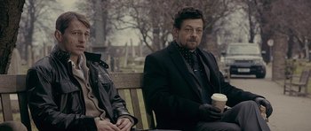 Movie still from “Wild Bill” (2011), directed by Dexter Fletcher – Two people sitting on a park bench one holding a cup; Medium shot, Over the shoulder angle