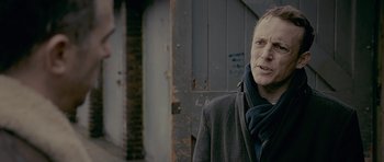 Movie still from “Wild Bill” (2011), directed by Dexter Fletcher – An older man wearing a coat and a scarf; Close Up shot, Over the shoulder angle