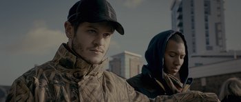 Movie still from “Wild Bill” (2011), directed by Dexter Fletcher – A man wearing a baseball cap and a jacket; Close Up shot, Over the shoulder angle