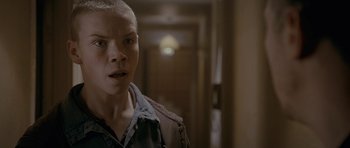 Movie still from “Wild Bill” (2011), directed by Dexter Fletcher – A person standing in a room with a door in the background; Close Up shot, Over the shoulder angle