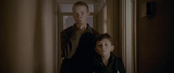 Movie still from “Wild Bill” (2011), directed by Dexter Fletcher – Two young men standing next to each other in a hallway; Medium shot, Low angle