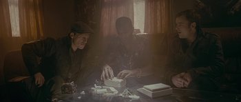 Movie still from “Wild Bill” (2011), directed by Dexter Fletcher – Two men sitting at a coffee table with cigarettes; Medium shot, Low angle
