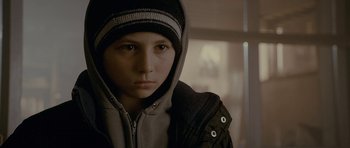Movie still from “Wild Bill” (2011), directed by Dexter Fletcher – A young boy wearing a hooded jacket and a hat; Close Up shot, Low angle