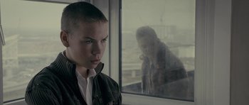 Movie still from “Wild Bill” (2011), directed by Dexter Fletcher – A young boy looking out of a window at an older woman; Close Up shot, Over the shoulder angle