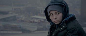 Movie still from “Wild Bill” (2011), directed by Dexter Fletcher – A young boy wearing a hooded jacket in a city; Close Up shot, Low angle