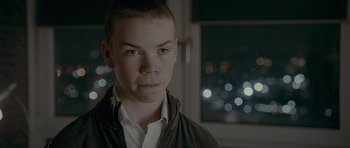 Movie still from “Wild Bill” (2011), directed by Dexter Fletcher – A young man with short brown hair wearing a white shirt; Close Up shot, Over the shoulder angle