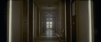 Movie still from “Wild Bill” (2011), directed by Dexter Fletcher – An empty hallway with a door open and a bicycle in it; Extreme Wide shot, Low angle