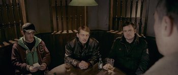 Movie still from “Wild Bill” (2011), directed by Dexter Fletcher – Two men sitting at a table with drinks in front of them; Medium shot, High angle
