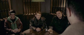 Movie still from “Wild Bill” (2011), directed by Dexter Fletcher – Two men sitting at a table with drinks in front of them; Medium shot, High angle