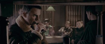 Movie still from “Wild Bill” (2011), directed by Dexter Fletcher – A man drinking a glass of beer in front of other people; Close Up shot, Over the shoulder angle