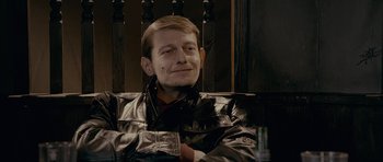 Movie still from “Wild Bill” (2011), directed by Dexter Fletcher – A man sitting in a chair with his arms crossed; Close Up shot, Low angle