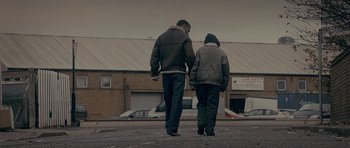 Movie still from “Wild Bill” (2011), directed by Dexter Fletcher – Two people walking down a street holding hands; Wide shot, Low angle