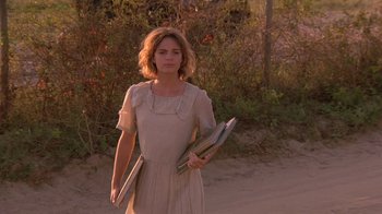 Movie still from “Wild Hearts Can't Be Broken” (1991), directed by Steve Miner – A woman in a dress holding a book in her hands; Medium shot, Over the shoulder angle