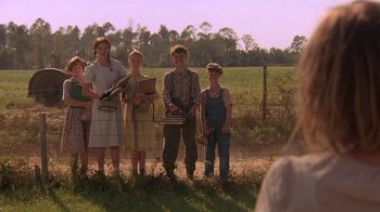 Movie still from “Wild Hearts Can't Be Broken” (1991), directed by Steve Miner – A group of people standing next to each other in a field; Wide shot, Over the shoulder angle